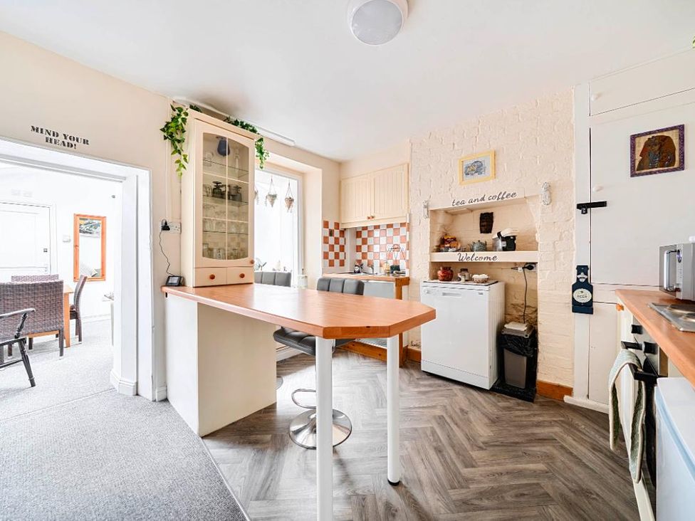 A kitchen with a table and stools at Charming Lincoln Cottage in Lincoln