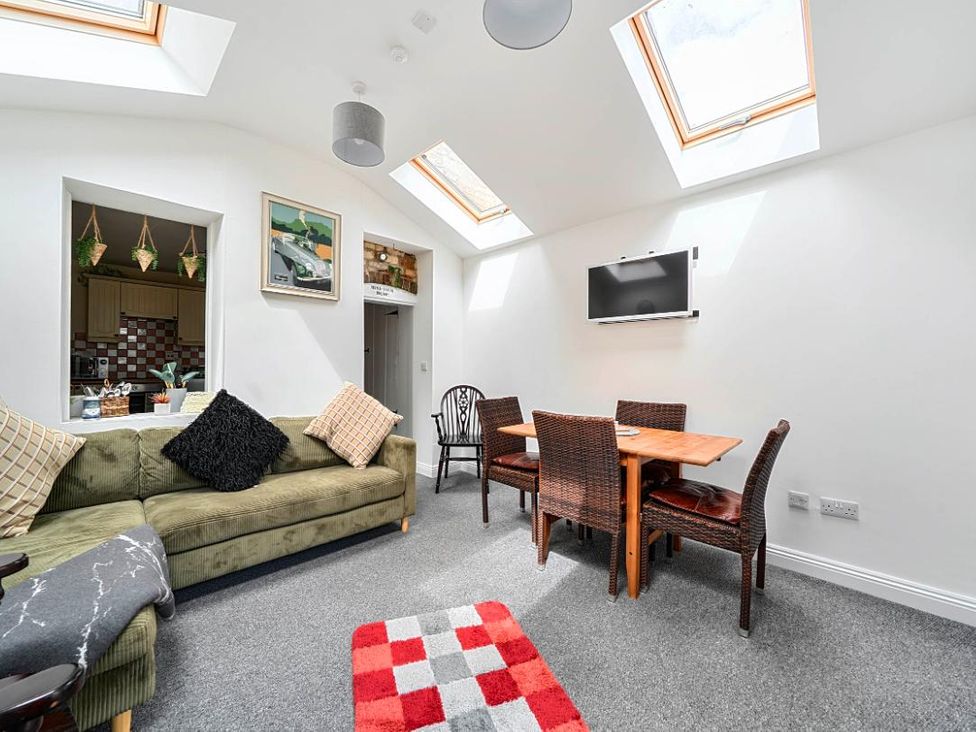 A living room with a sofa and dining area at Charming Lincoln Cottage in Lincoln