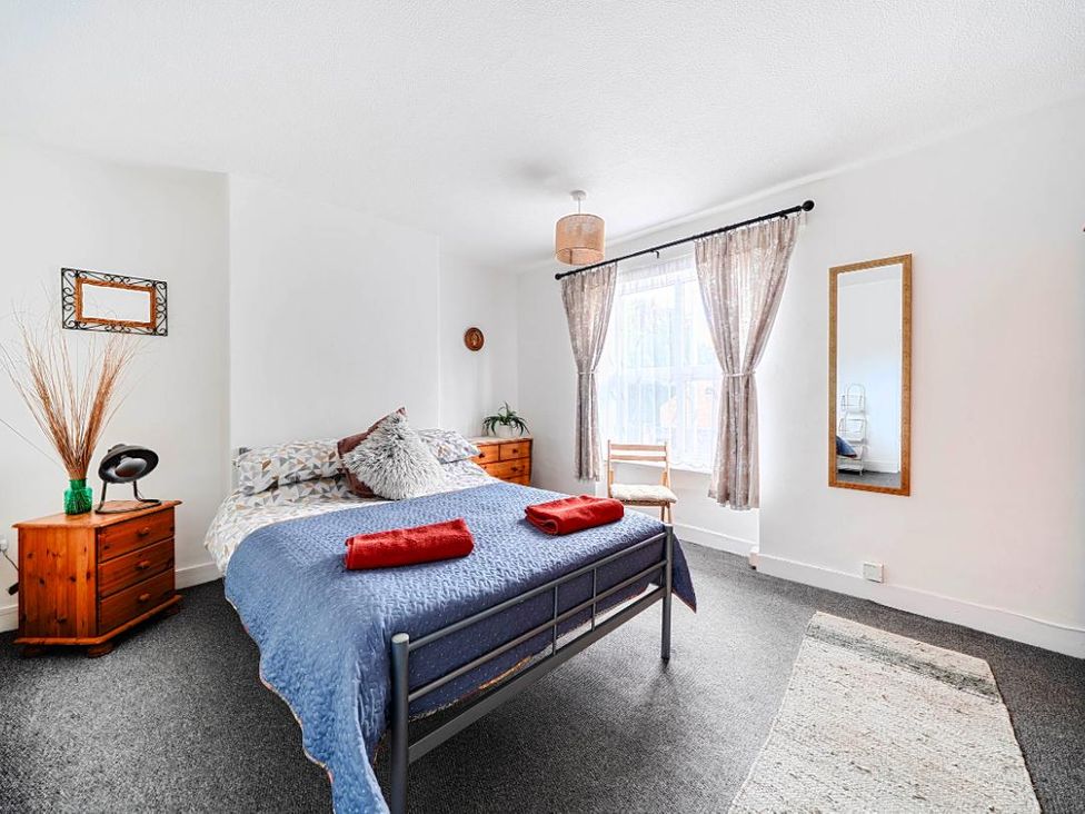 A bedroom with a bed and side table at Charming Lincoln Cottage in Lincoln
