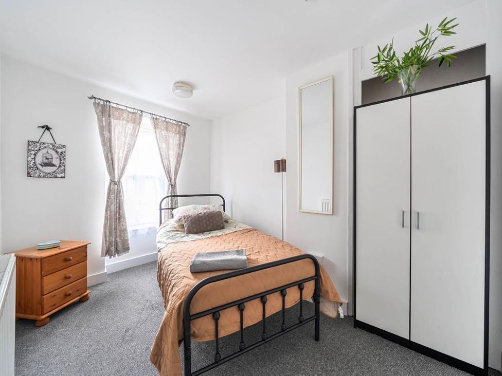 A bedroom with a bed and wardrobe at Charming Lincoln Cottage in Lincoln