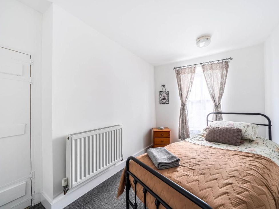 A bedroom with a bed and nightstand at Charming Lincoln Cottage in Lincoln