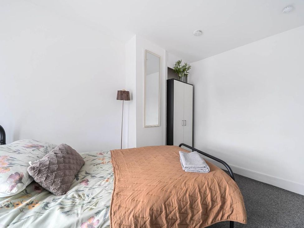 A bedroom with a bed and wardrobe at Charming Lincoln Cottage in Lincoln