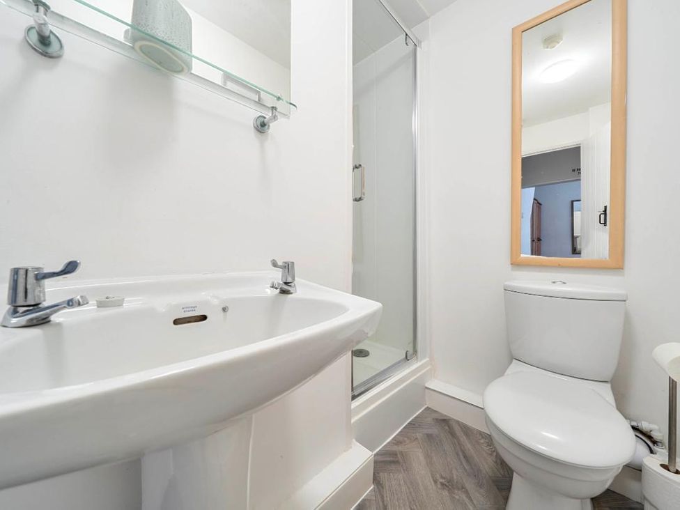 A bathroom with a sink, toilet, and shower at Charming Lincoln Cottage in Lincoln