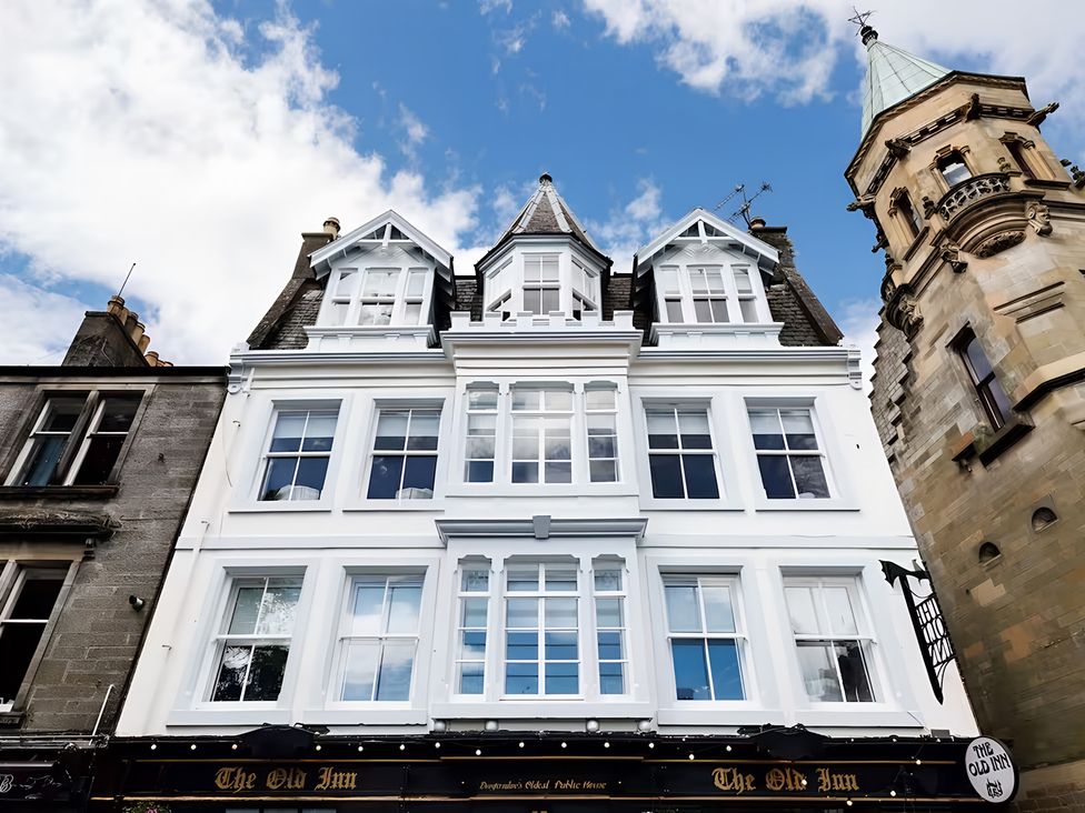 A building with a sign reading The Old Inn and tower at The Old Inn in 