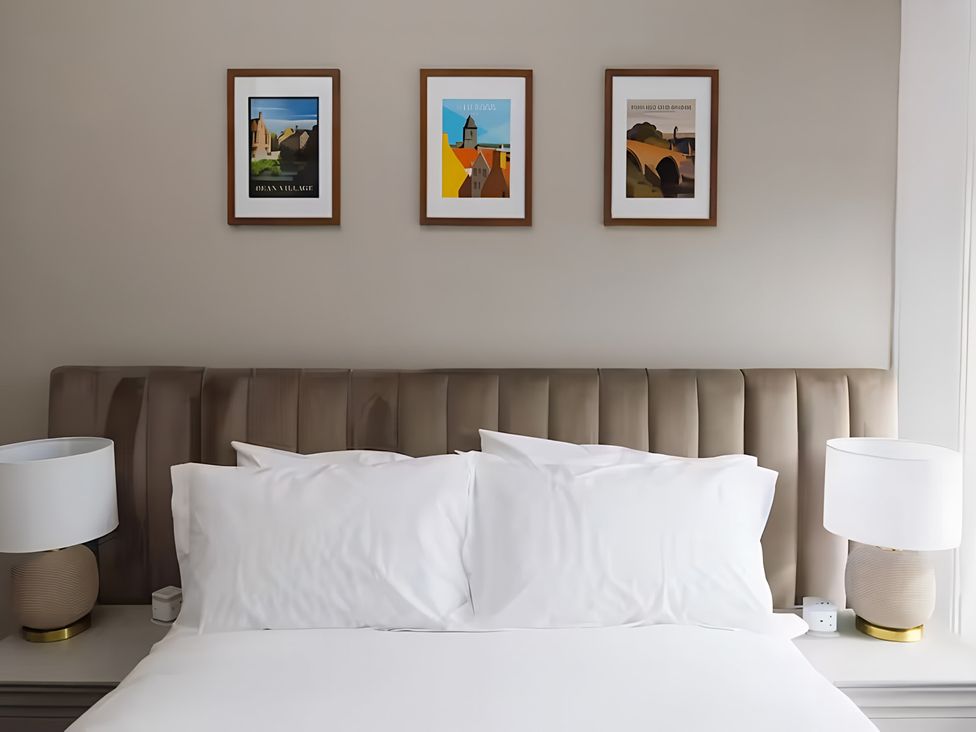 A bedroom with a bed and wall art at 15B Kirkgate