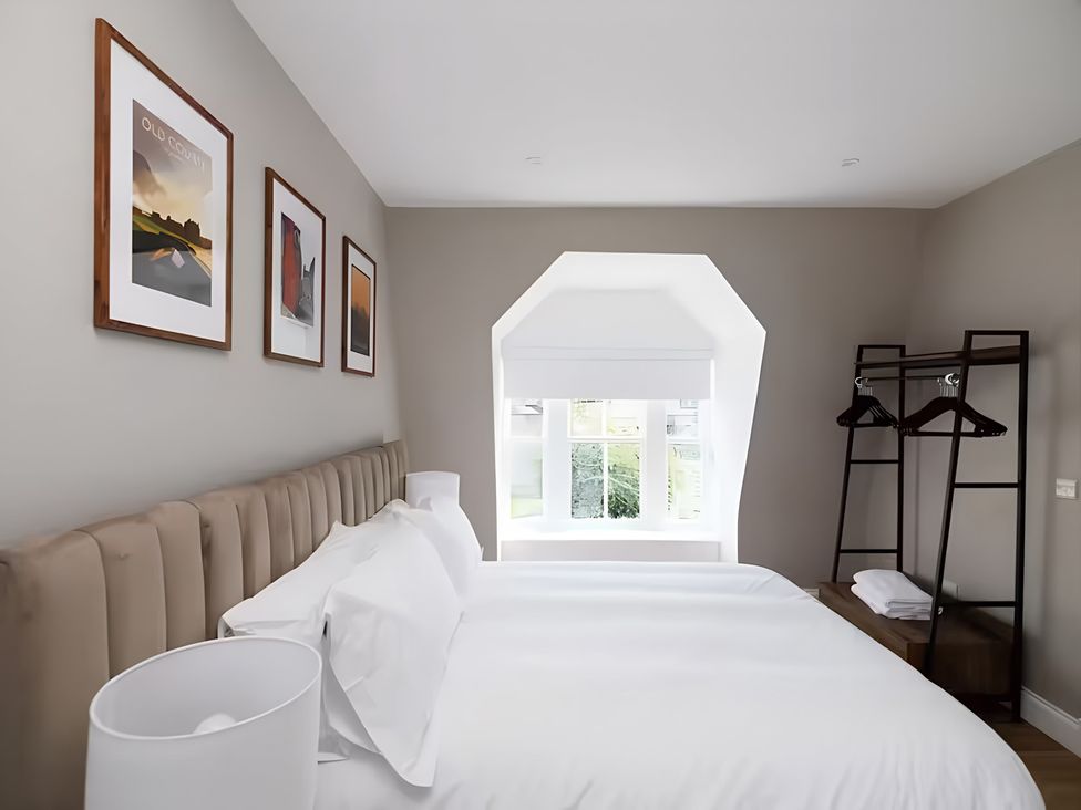 A bedroom with a bed and art on the walls at 15D Kirkgate 