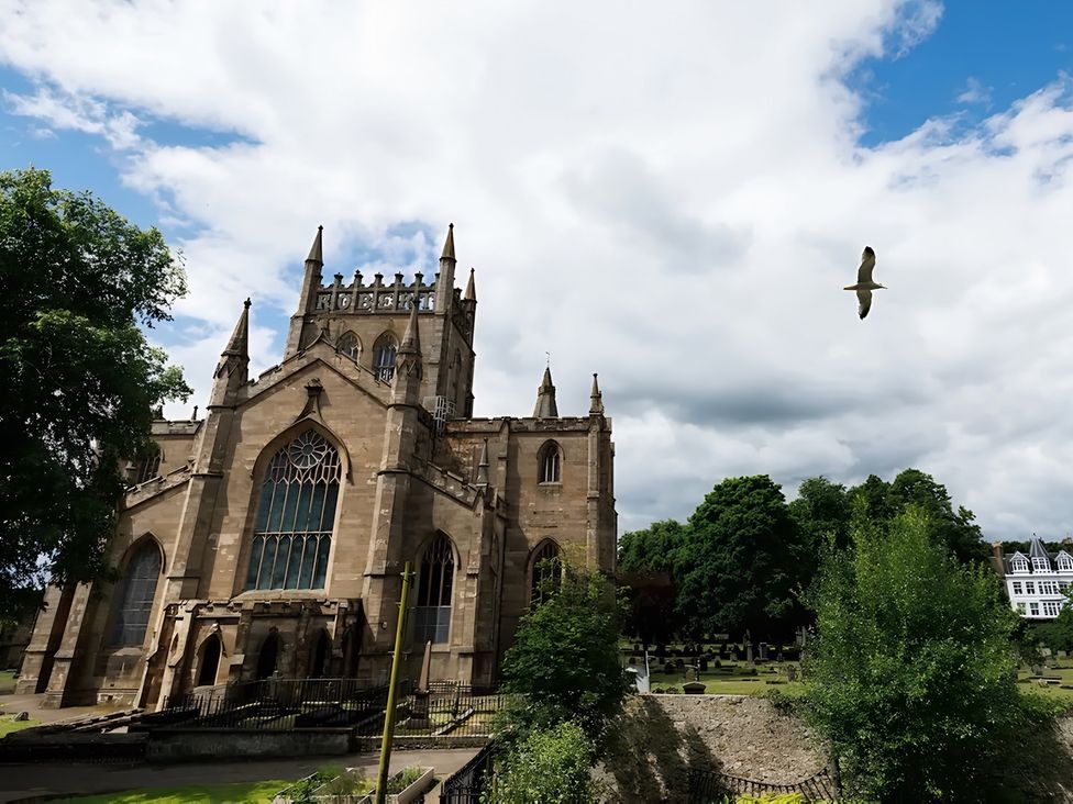 A church with a graveyard and trees at 15D Kirkgate