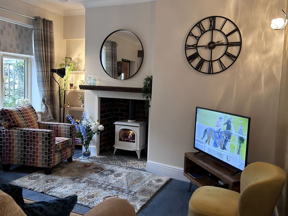 A living room with a television and a fireplace at The Old Barn in Manchester