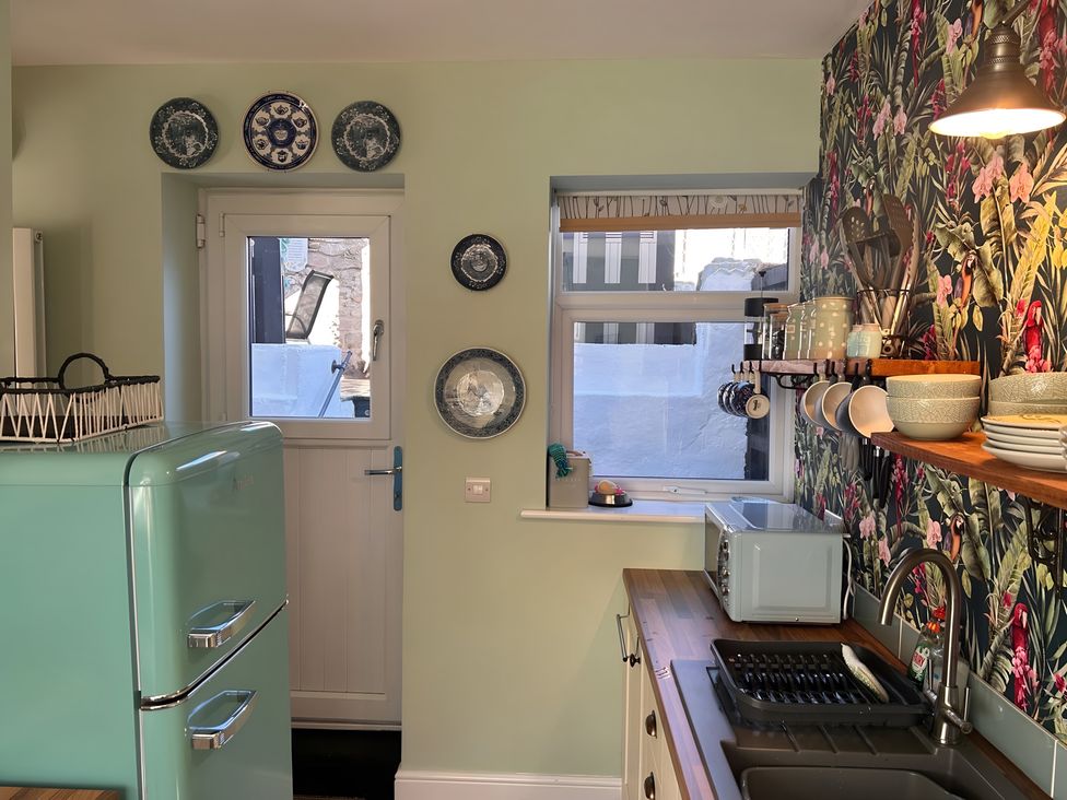 A kitchen with a refrigerator and plates on the wall at The Old Barn in Manchester