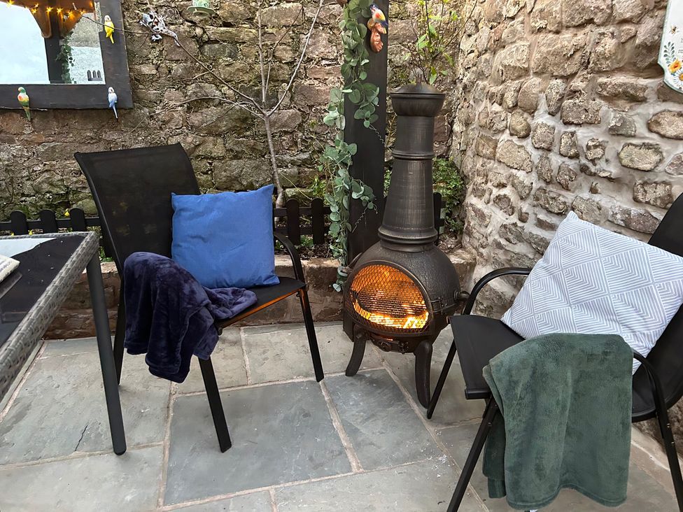 An outdoor seating area with chairs and a fireplace at the property in the location