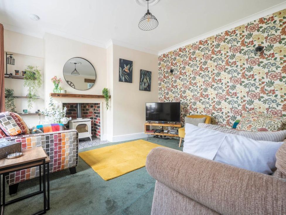 A living room with a fireplace and television at 20 Main Street Heysham