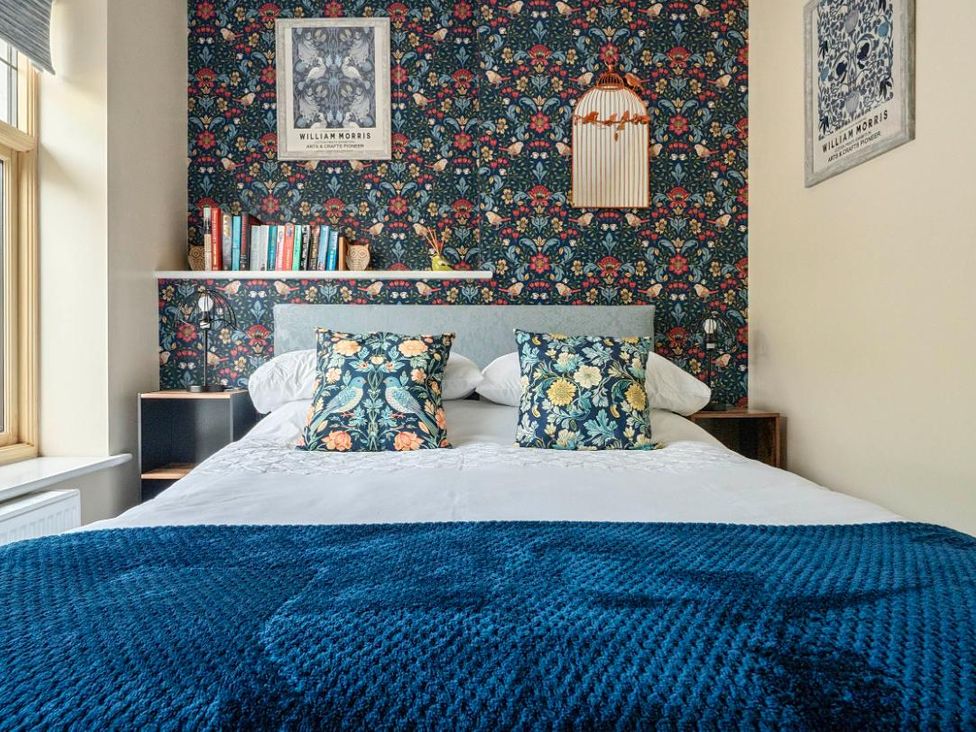 A bedroom with a bed and bookshelf at 20 Main Street in Heysham