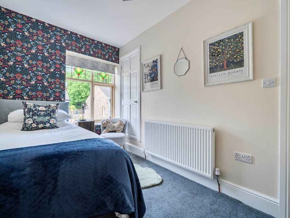 A bedroom with a bed and decorative wallpaper at 20 Main Street in Heysham