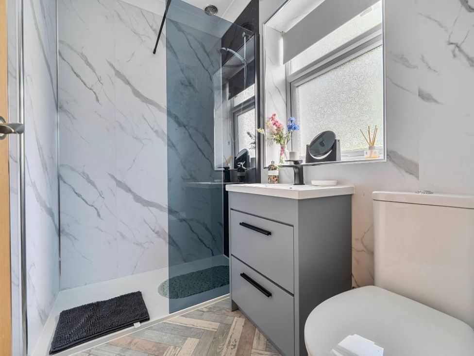 A bathroom with a shower, sink, and toilet at 20 Main Street Heysham