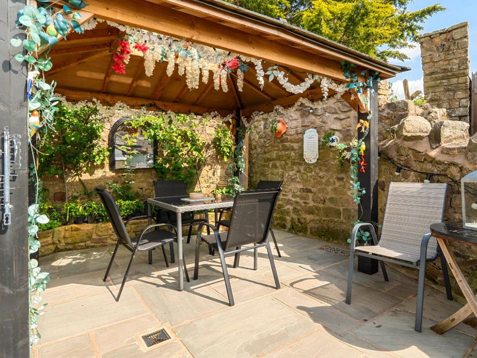 An outdoor dining area with table and chairs at 20 Main Street in Heysham