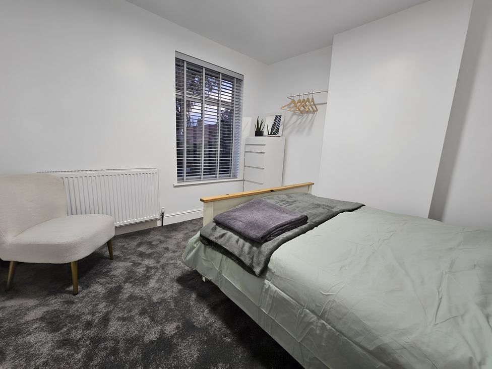 A bedroom with a bed and a chair at 140 Finchley Road