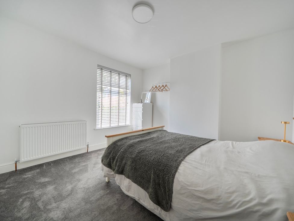 A bedroom with a bed, radiator, wardrobe, and window at 140 Finchley Road Ipswich