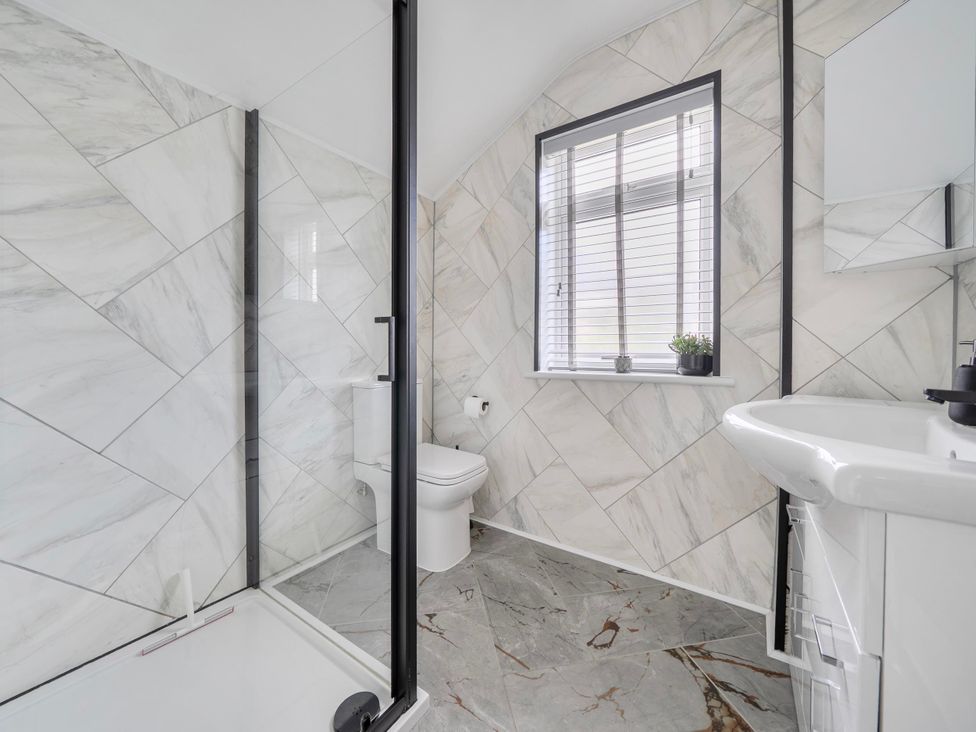 A bathroom with shower, toilet, sink and window at 140 Finchley Road Ipswich