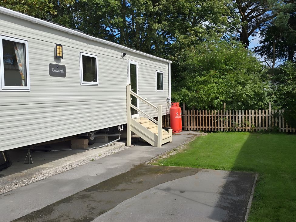 An outdoor area with a caravan and a lawn at Caravan