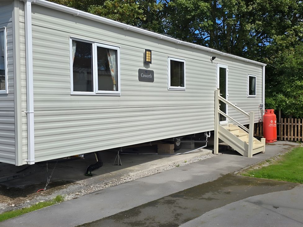 A caravan with stairs and a gas cylinder at Coworth
