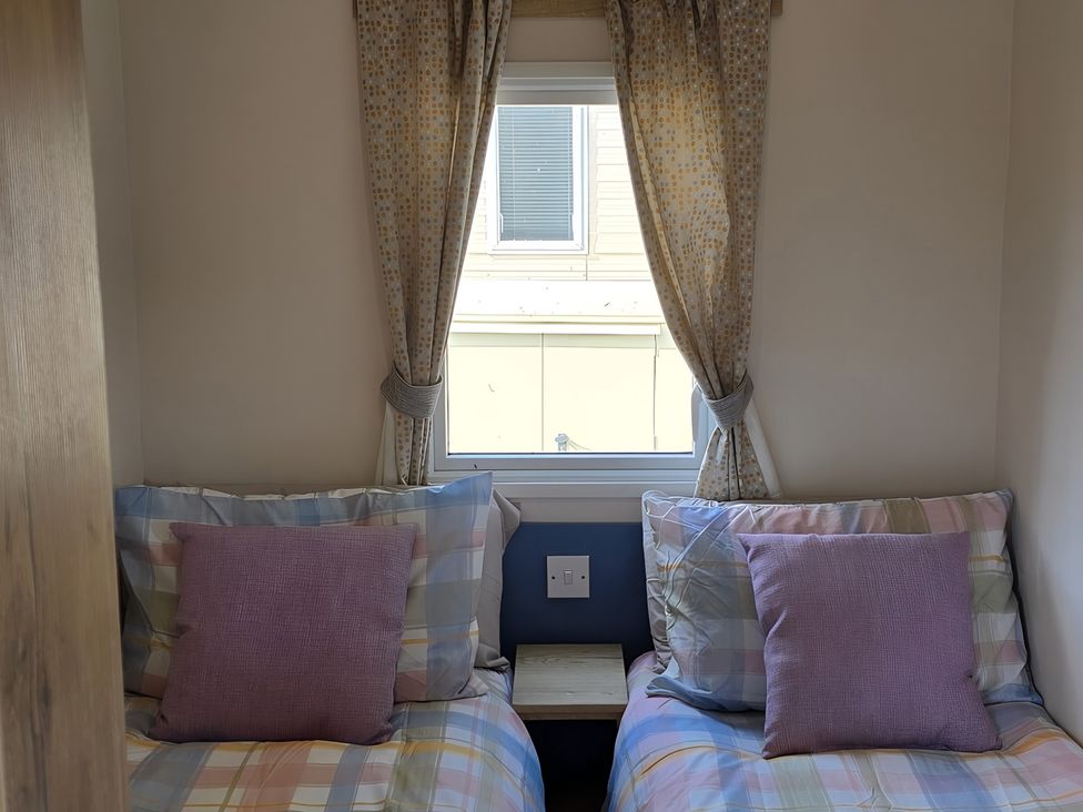 A bedroom with two beds and a window at Caravan