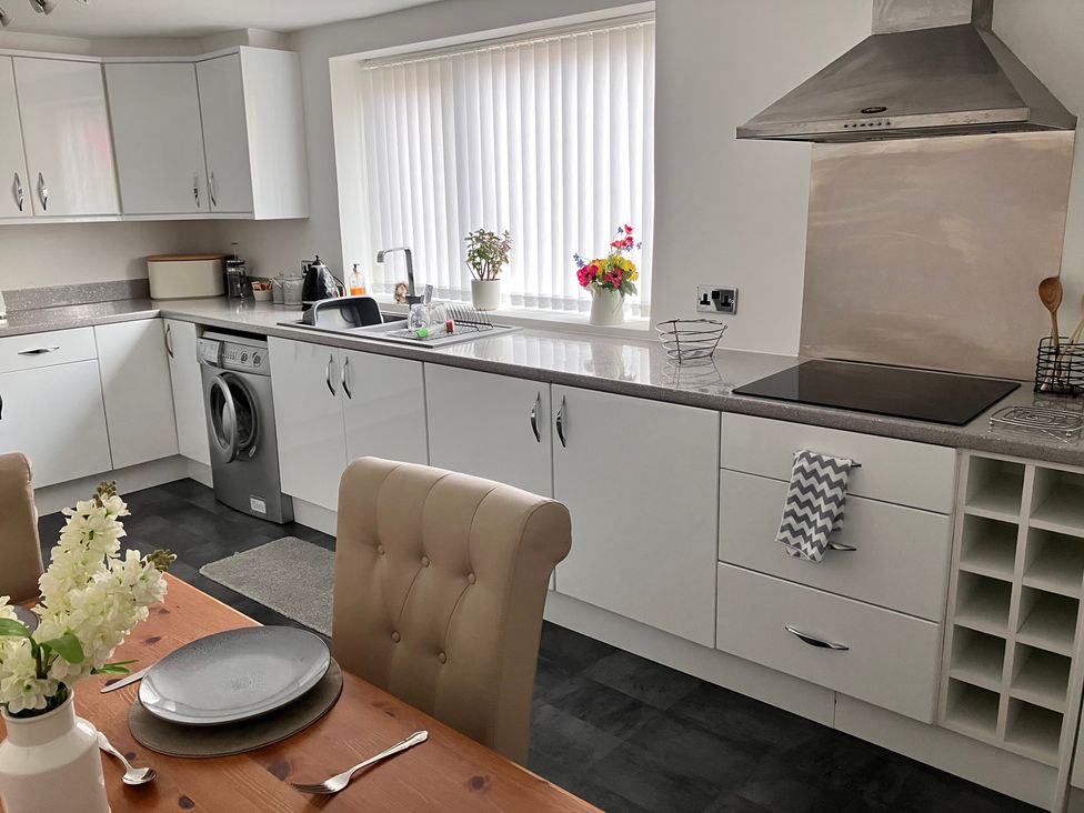 A kitchen with appliances and dining area at Flat 2A 