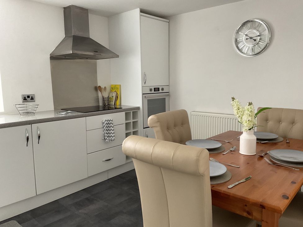 A kitchen with an extractor hood and dining table at Flat 2A