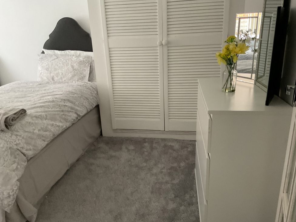 A bedroom with a bed and dresser at Flat 2A 