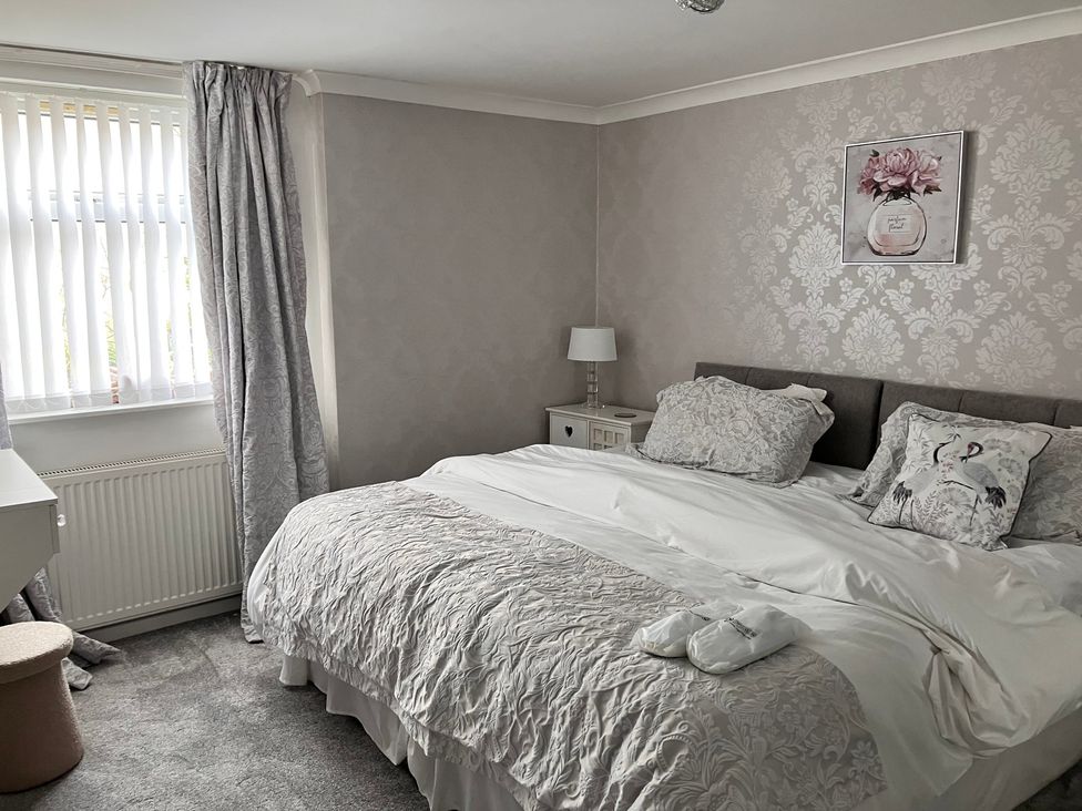 A bedroom with a bed and bedside table at Flat 2A