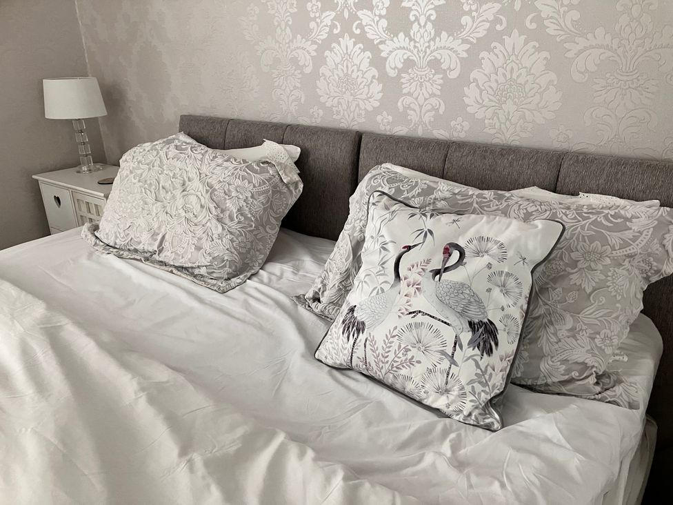 A bedroom with a bed and two pillows at Flat 2A