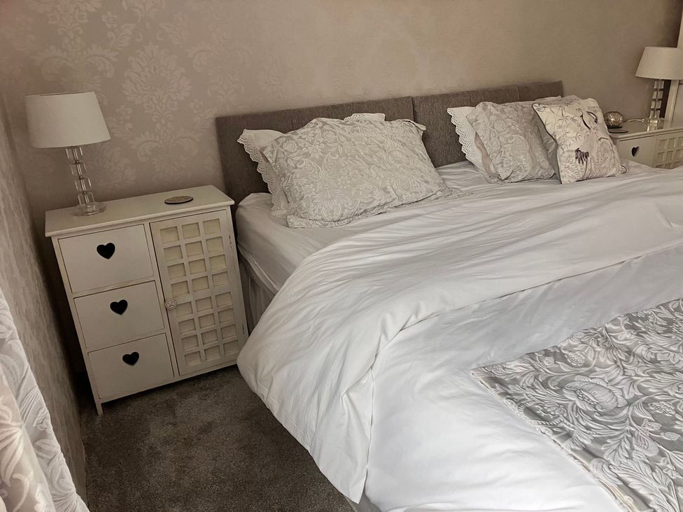 A bedroom with a bed and bedside table at Flat 2A