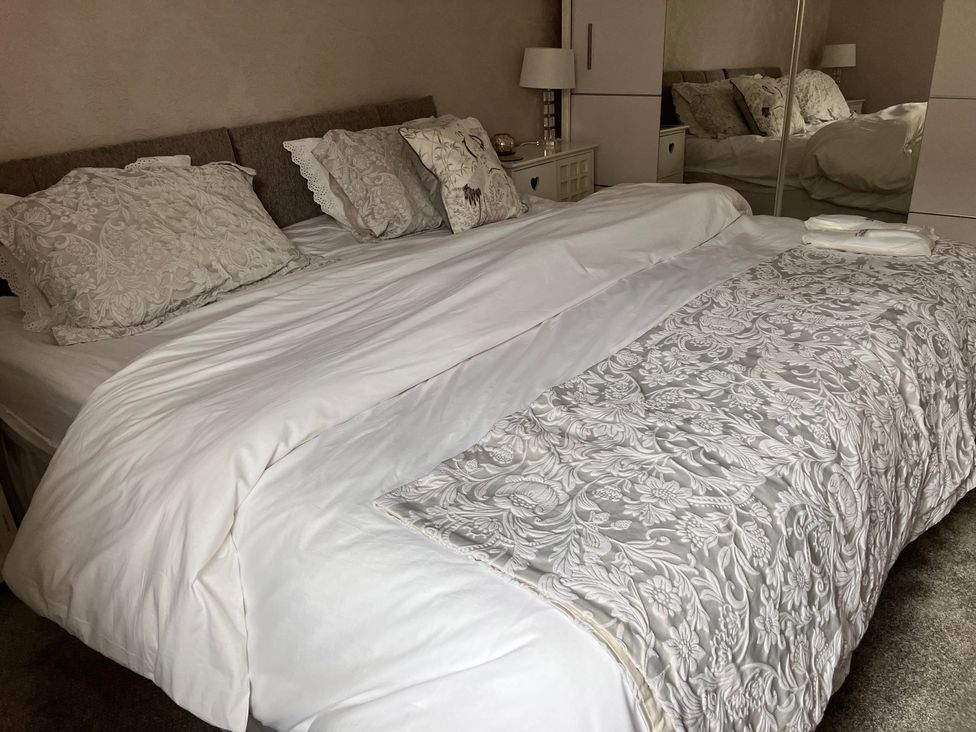 A bedroom with a bed and bedside table at Flat 2A