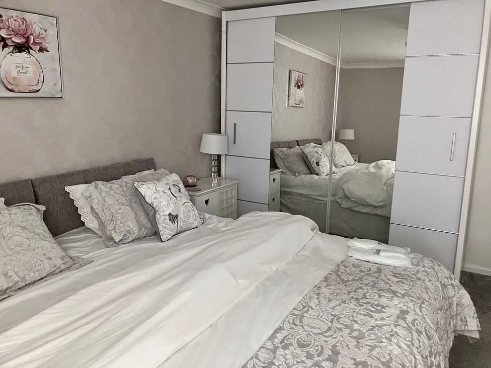 A bedroom with a bed and bedside table at Flat 2A