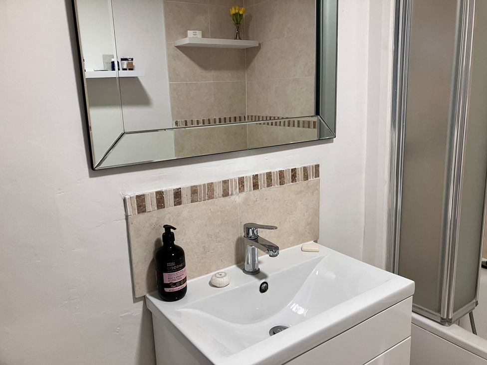 A bathroom with a sink and mirror at Flat 2A
