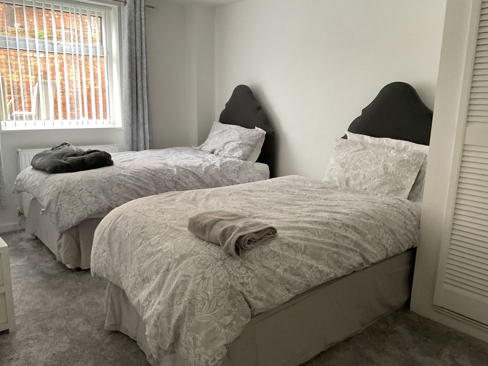 A bedroom with two beds and window at Flat 2A 