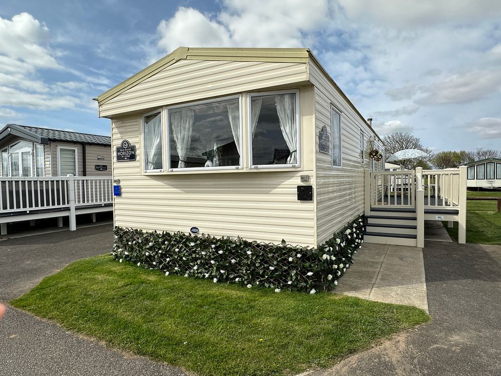 A mobile home with windows and steps at a holiday park in location