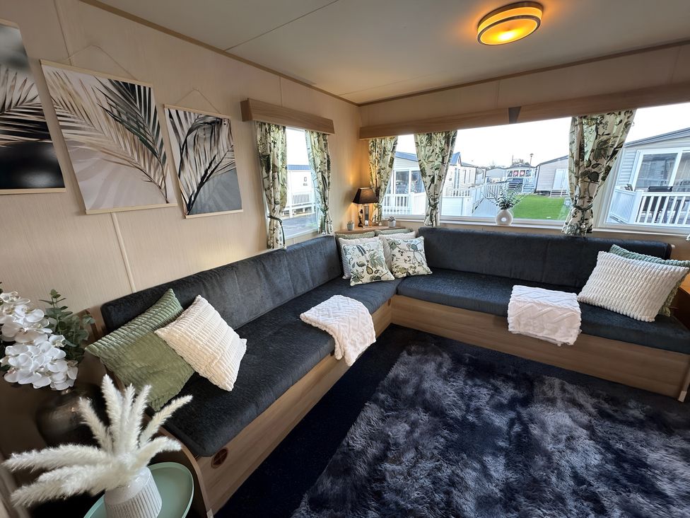 A living room with a sectional sofa and plant at the property