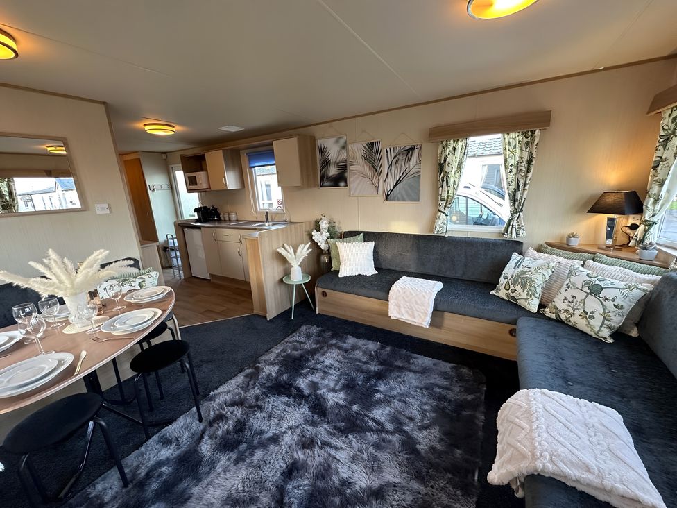 A living room with a sofa and dining area at The Old Barn in Manchester