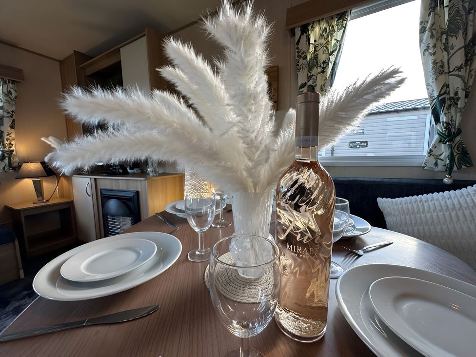 A dining table set with plates and wine bottle at a dining area in a property