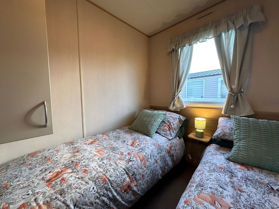 A bedroom with two beds and a lamp at the property in location