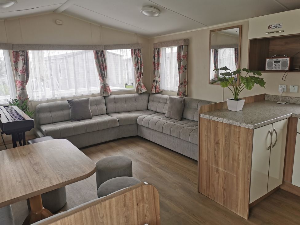 A living room with a sofa and table in a holiday home