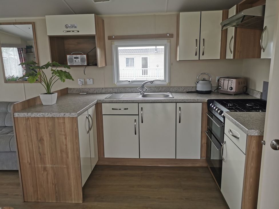 A kitchen with a sink, stove, and cabinets at 