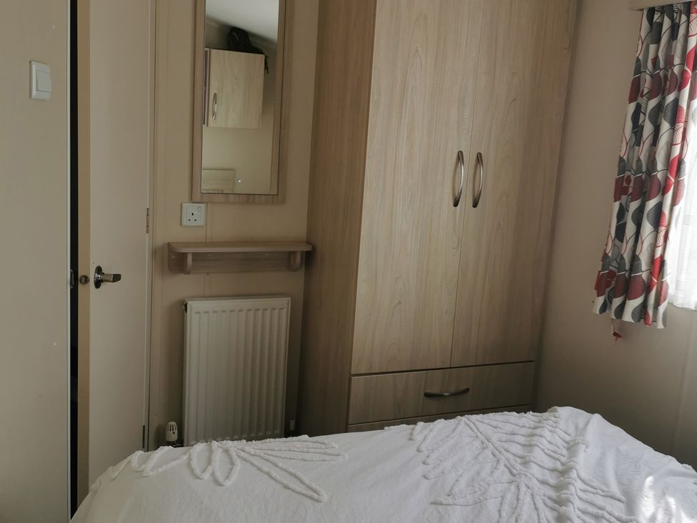 A bedroom with a wardrobe and a mirror at the property