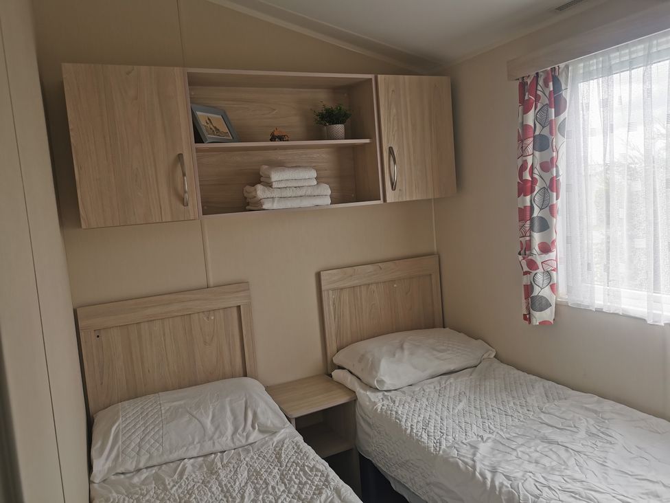 A bedroom with two single beds and a shelf at the property in 