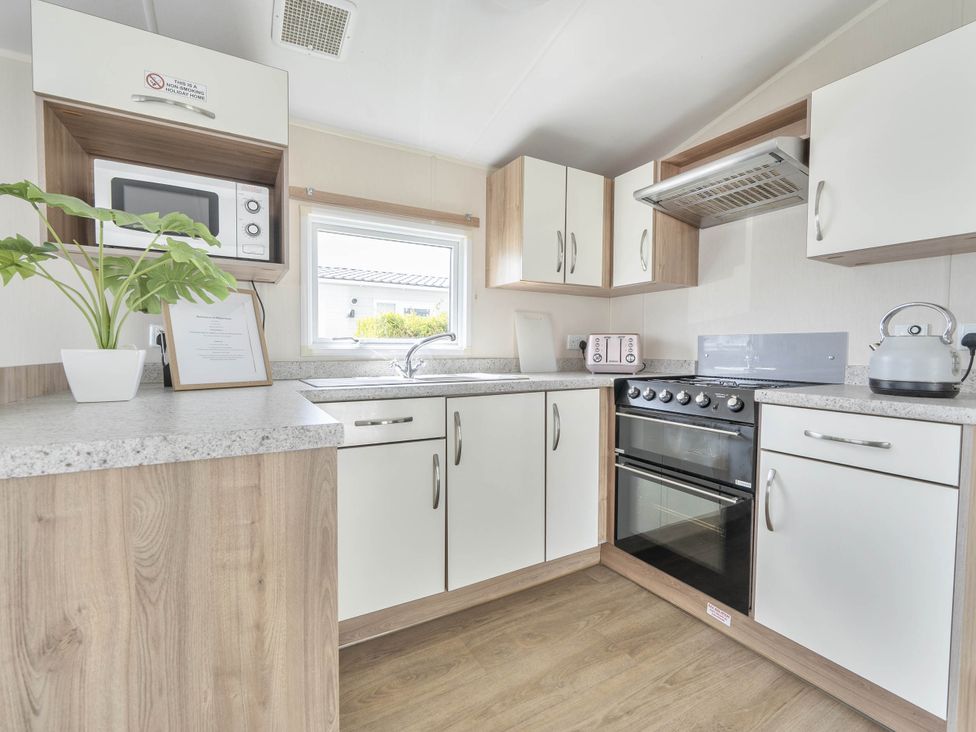 A kitchen with appliances and sink at Mersea Beach Retreat in Colchester