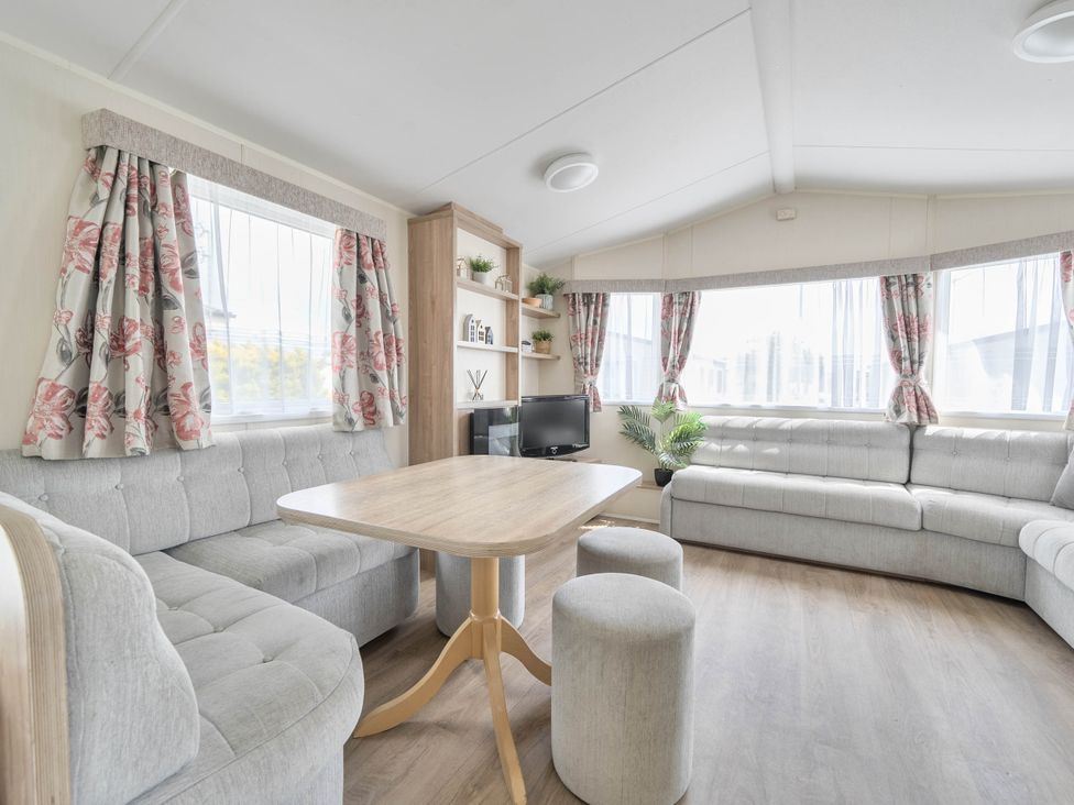 A living room with a table and sofa at Mersea Beach Retreat in Colchester