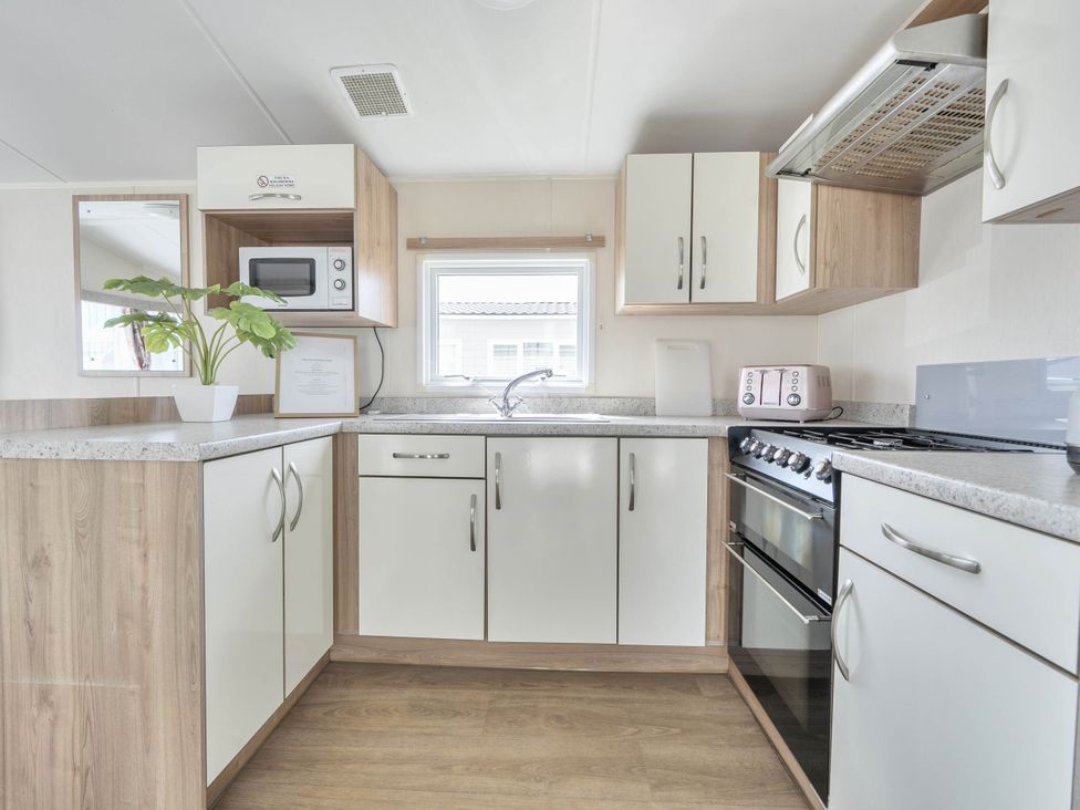 A kitchen with a sink and appliances at Mersea Beach Retreat in Colchester