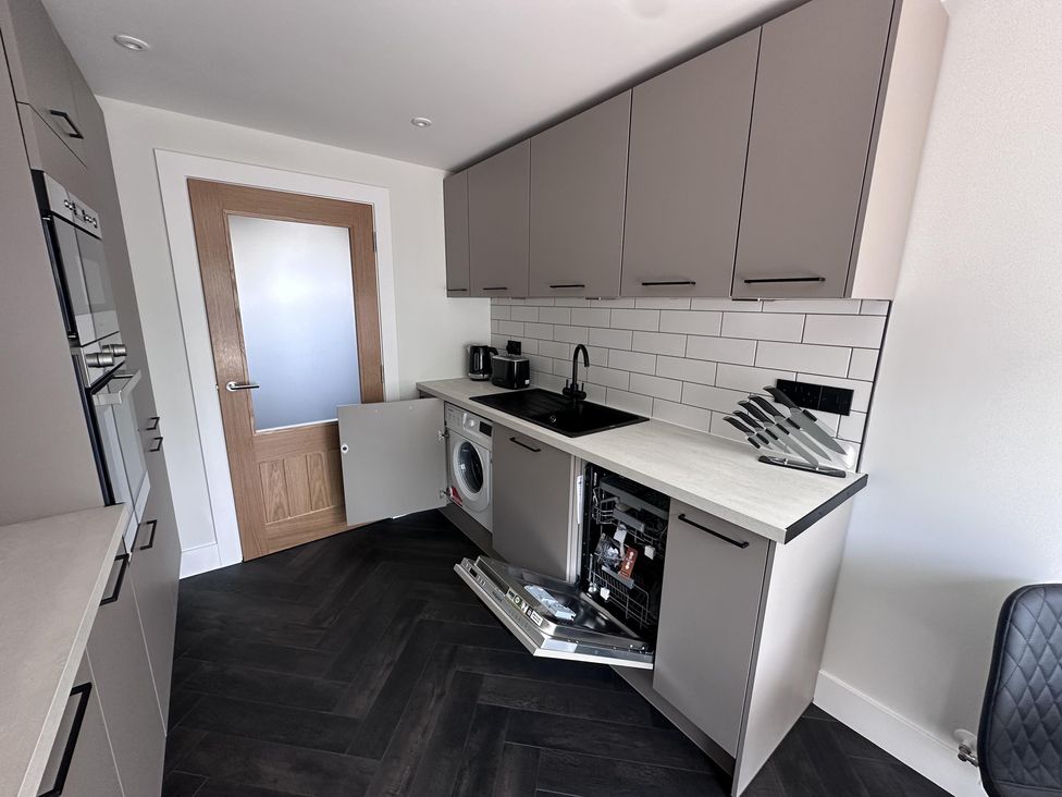 A kitchen with cabinets, sink, washing machine and dishwasher at 22 Fraser Avenue