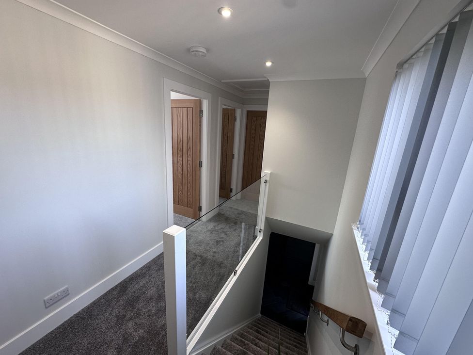 A hallway with doors and a staircase at 22 Fraser Avenue