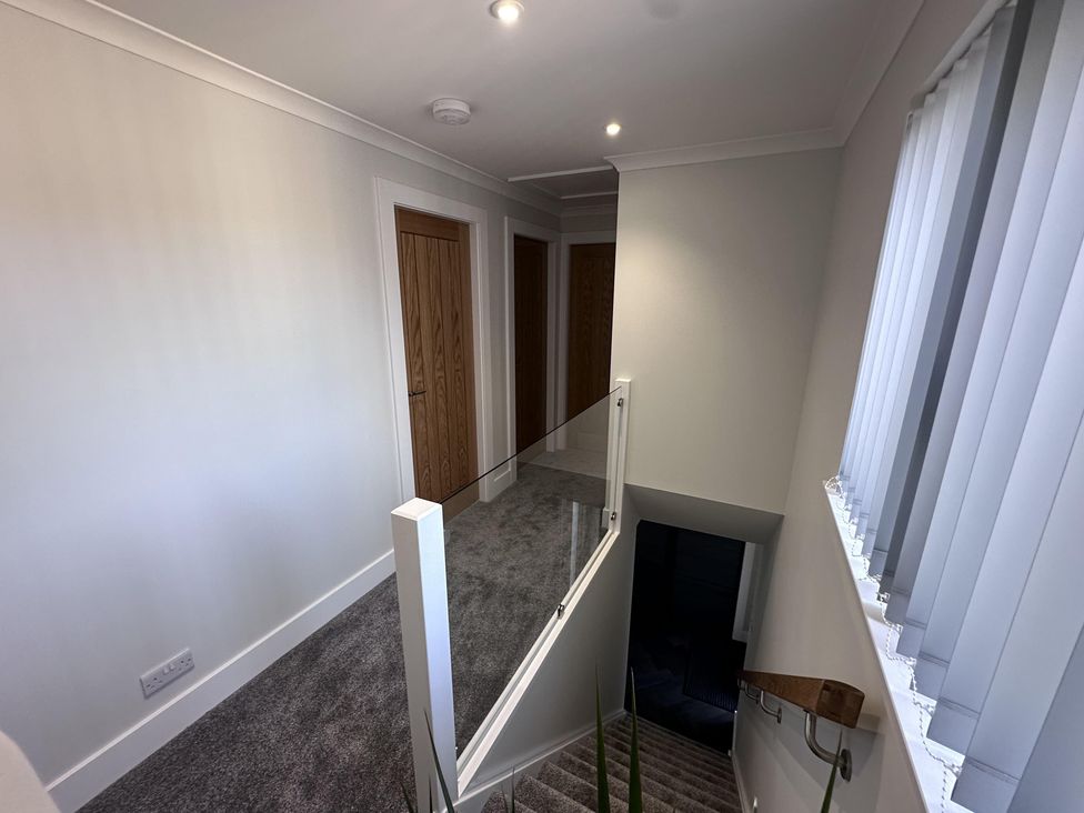 A hallway with a staircase and doors at 22 Fraser Avenue